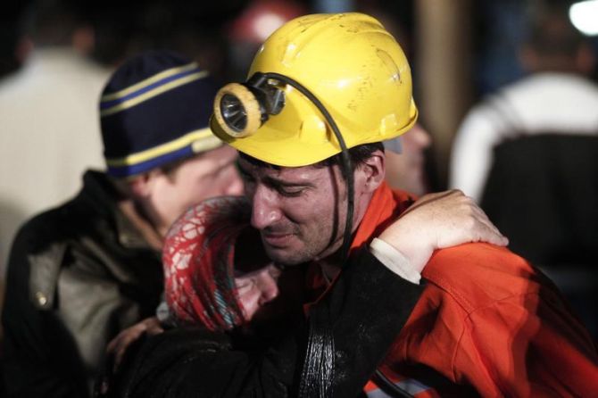 A miner hugs a relative in front of the coal mine site in Soma after the blast killed 201 miners.