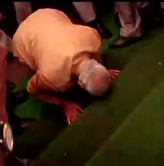 Modi touches his forehead on the steps at the entrance of the Parliament.
