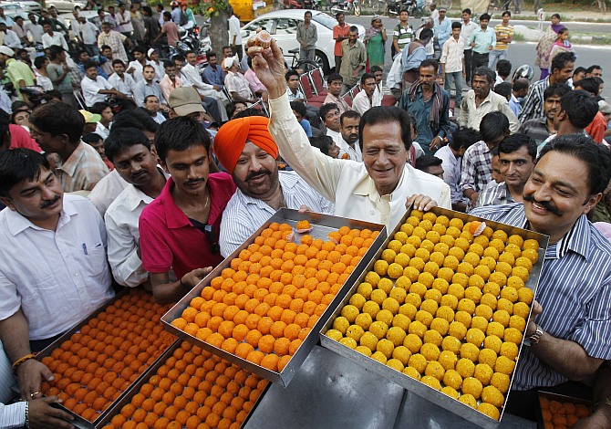 Supporters of Bharatiya Janata Party distribute sweets during celebrations after Narendra Modi was sworn in as India's prime minister, in Chandigarh