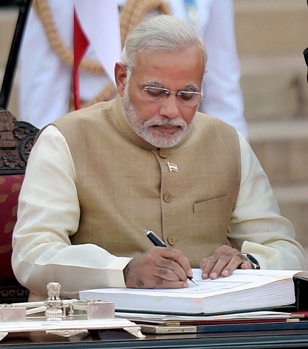 Narendra Modi signs the register after taking oath as the 15th Prime Minister of India, at a ceremony at Rashtrapati Bhavan in New Delhi 