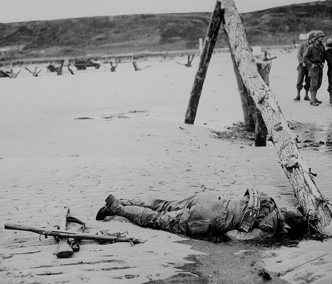 Crossed rifles lay in the sand as a comrade's tribute to a dead American soldier