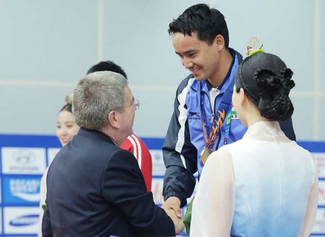 IOC President Thomas Bach presents Rai Jitu of India with his gold medal in the 50m Pistol Men's event at Ongnyeon International Shooting Range 