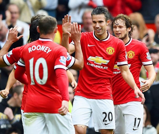 Robin van Persie of Manchester United celebrates with teammates after scoring his team's second goal during the Barclays Premier League match against West Ham United