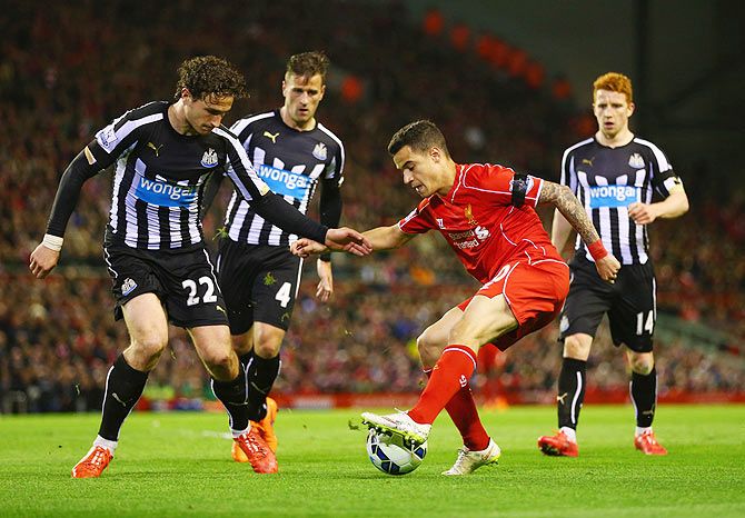  Liverpool's Philippe Coutinho dances past Newcastle defenders Ryan Taylor (4) Daryl Janmaat (22) and Jack Colback during their Premier League match at Anfield on Monday