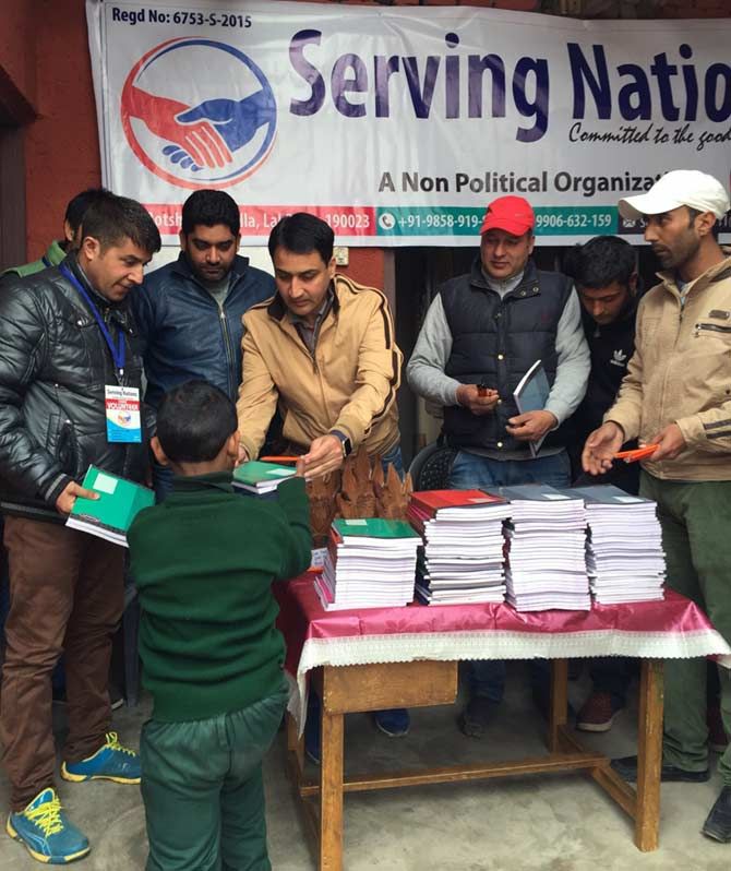 Mawa distributing notebooks to school students