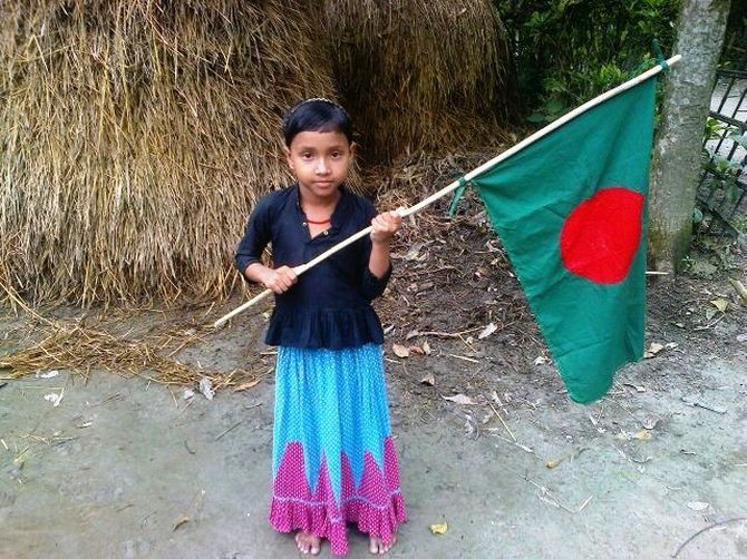 A girl holds a Bangladeshi flag
