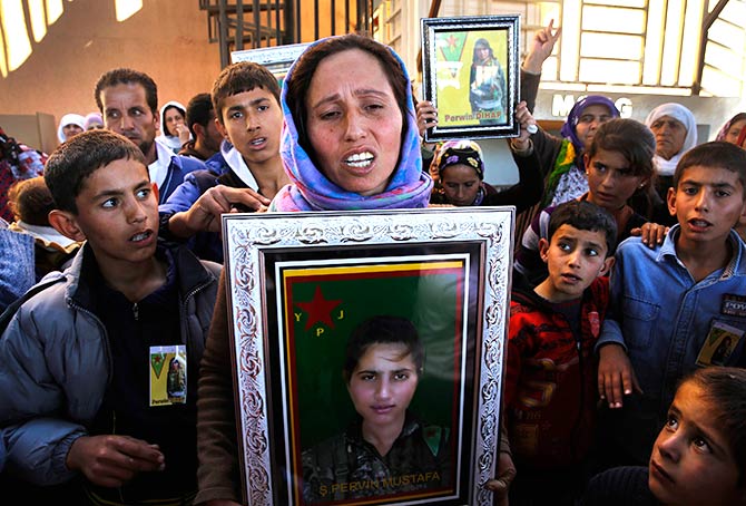 Jamila holds a photograph of her sister Perwin Mustafa Dihap, a 19-year-old fighter who died fighting Islamic State.