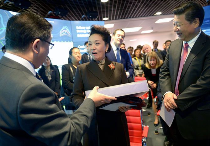 Chinese First Lady Peng Liyuan is surprised with a gift by Professor Yike Guo during a visit to the Imperial College in London, October 21, as her husband President Xi Jinping smiles and Britain's Chancellor of the Exchequer George Osborne leans forward to get a better look. Photograph: Anthony Devlin/Reuters