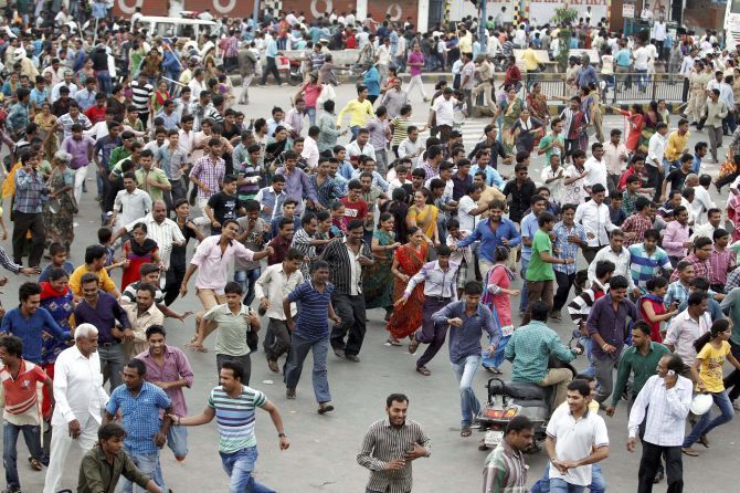 Patels run for cover after a police lathi charge to disperse crowds protesting against the arrest of their leader Hardik Patel. Photograph: PTI
