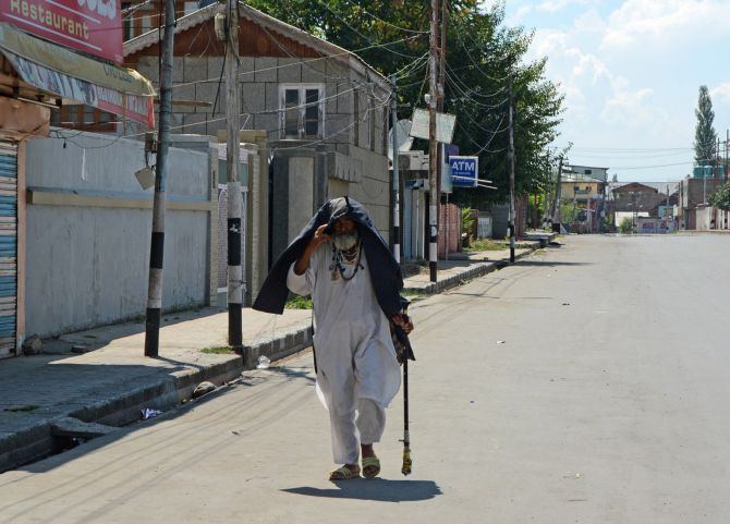 An elderly man walks on a deserted street in Srinagar. Photograph: Umar Ganie