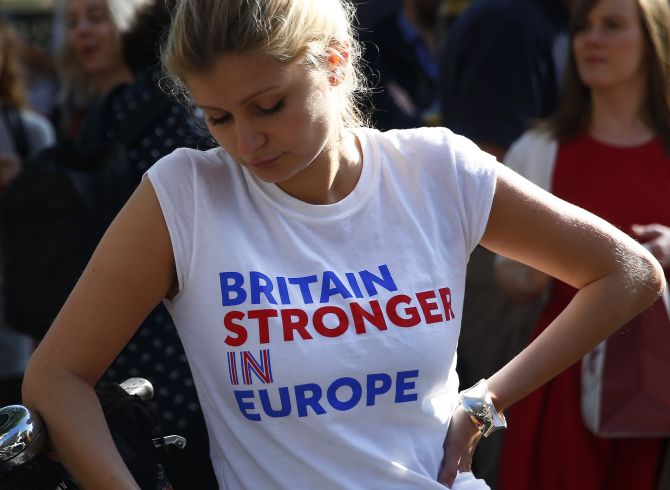 A woman wearing a vote remain T-shirt reacts, following the result of the EU referendum, in London.