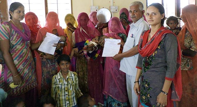 Birth certificates are handed over during a Balika Janamotsav in Jalore, Rajasthan