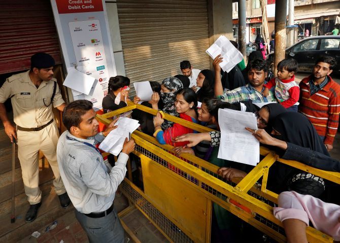 A bank employee hands out request slips for the exchange of old high denomination bank notes at a bank in Old Delhi. Photograph: Cathal McNaughton/Reuters