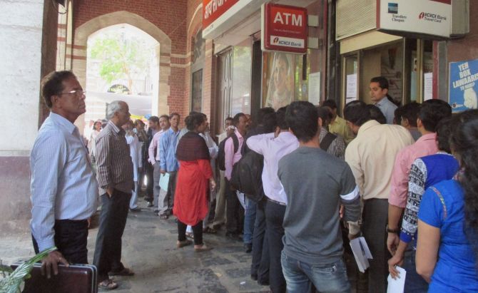 People queue up for money outside a bank in Mumbai