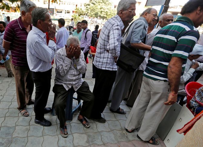 People wait to exchange old currency notes