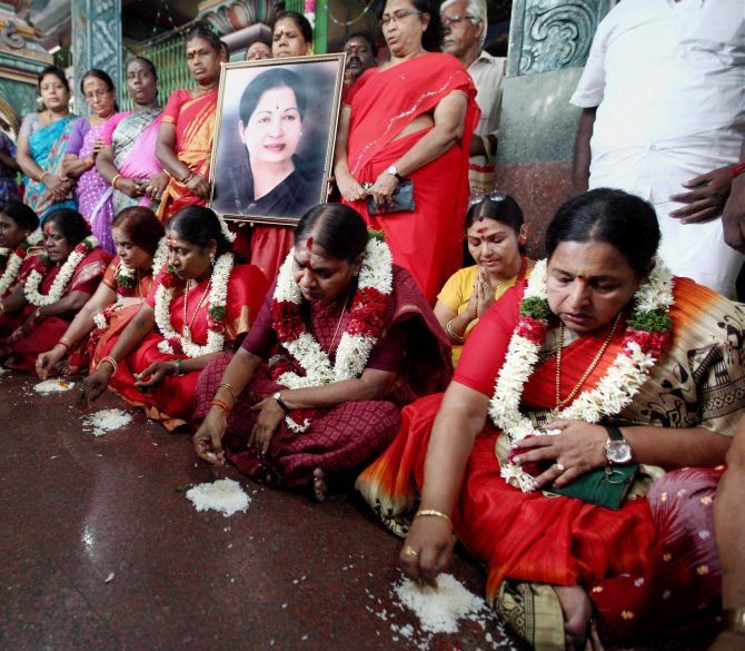 Members of the AIADMK women's wing eat food from the floor as a prayer for the speedy recovery of party supremo and Chief Minister J Jayalalithaa at a temple in Chennai. Photograph: PTI Photo