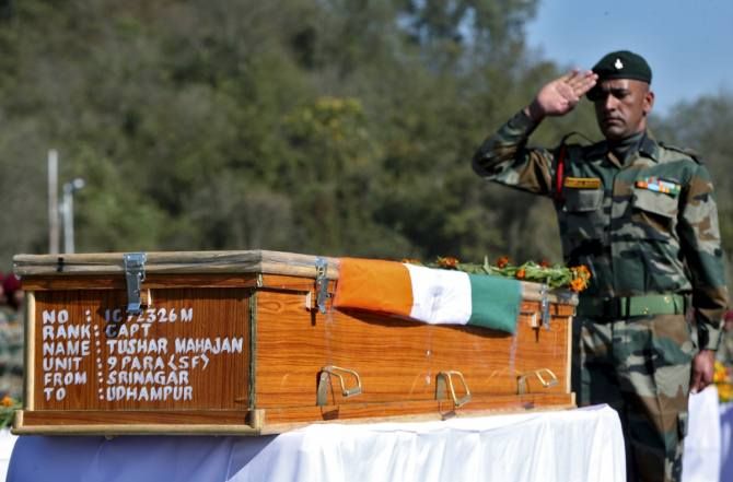 An Indian Army officer salutes at the coffin containing the body of Tushar Mahajan, an army officer who was killed in a gunbattle, in Udhampur, north of Jammu. 