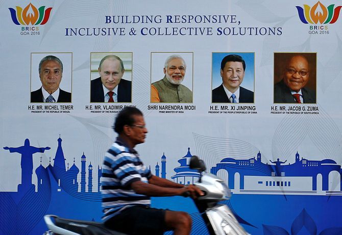A man rides past a billboard near one of the venues of BRICS summit in Goa. Photograph: Danish Siddiqui/Reuters