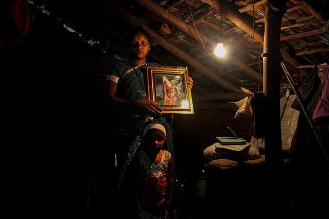 Mamta Gurunath Savar holds a photograph of her daughter Roshni who died of malnutrition last year. Mamta and her other daughter Shalini live in Petranjani village, Mokhada taluka, Palghar district, Maharashtra in Mumbai's backyard. Photograph: Uttam Ghosh/Rediff.com