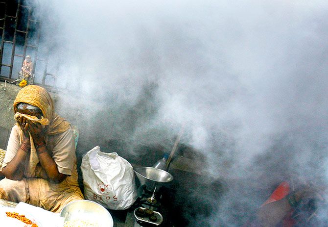 A street hawker covers her face during fumigation at a health drive by an Indian radio channel to create awareness about malaria in Mumbai July 25, 2007. Photo: Arko Dutta/Reuters