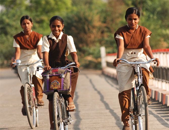 Young girls cycling to school