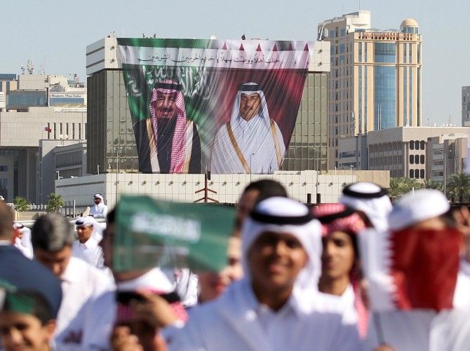 A poster shows Saudi King Salman and Qatar's Emir Sheikh Tamim Bin Hamad Al-Thani as people wave Qatari and Saudi flags during a welcoming ceremony for King Salman at the Royal Court on Doha Corniche, Qatar, December 5, 2016. Photograph: Naseem Zeitoon/Reuters