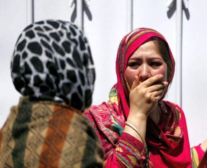 Relatives of Afghan victims mourn after the Kabul terror attack