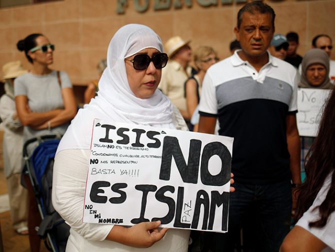 A Muslim woman holds a sign that reads 'ISIS is not Islam' as she takes part in a gathering of Muslim, Christian and Jewish communities in Fuengirola, southern Spain, August 20, 2017, to protest the ISIS attack in Barcelona a few days earlier. Photograph: Jon Nazca/Reuters