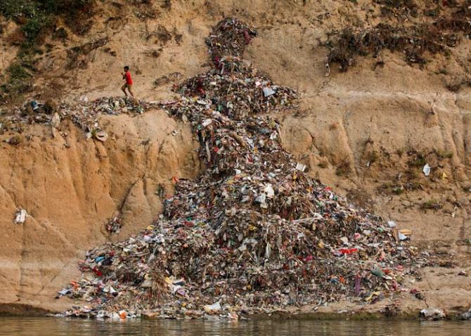 A boy runs past a pile of garbage along the river Ganges in Mirzapur, India, April 19, 2017. Photo: Danish Siddiqui/Reuters