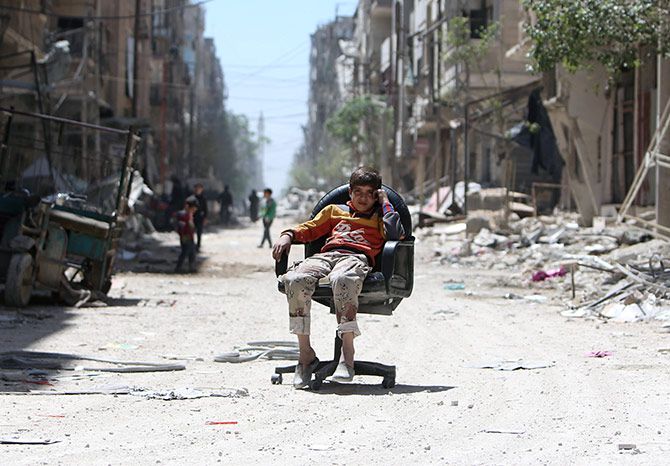 A boy sits along a damaged street in Douma, Damascus, Syria, April 16, 2018. Photograph: Ali Hashisho/Reuters