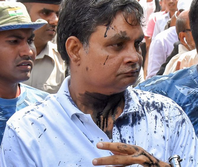 Brajesh Thakur, the main accused in the Muzaffarpur shelter home case, after a woman threw ink on his face while he was being taken to a special court in Muzaffarpur, August 8, 2018. Photograph: PTI Photo