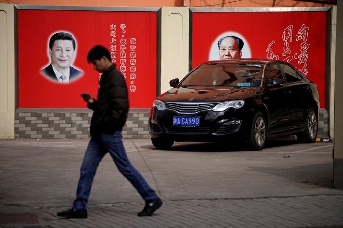 Portraits of Chinese President Xi Jinping and Mao Zedong overlook a street in Shanghai. Photograph: Aly Song/Reuters