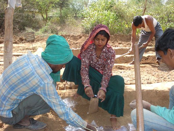 Locals filling soil in bags for distribution of the saplings