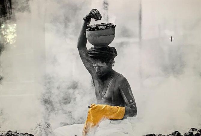 A sadhu surrounded by smoke from burning cow dung cakes