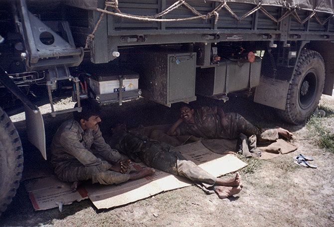 Fatigued soldiers take a rest under a truck during the War. Rediff Archives