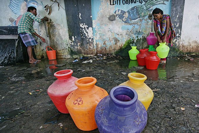 Residents fill their empty containers with water from a municipal tap in Chennai. Photograph: P Ravikumar/Reuters.