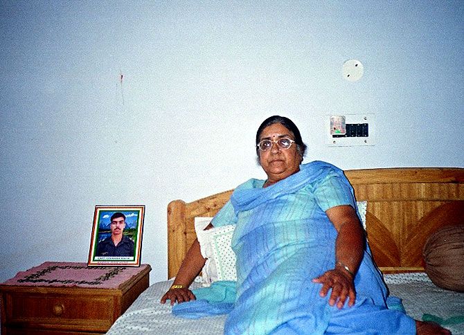 Captain Saurabh Kalia's mother with his picture by her bedside