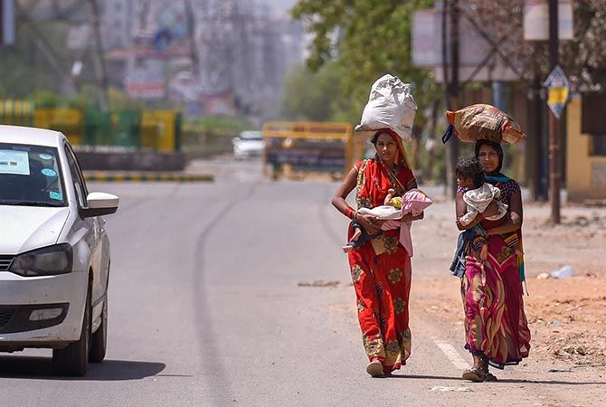 Women carrying their babies and essential items walk on a nearly-deserted street in Ghaziabad, April 7, 2020. Photograph: Atul Yadav/PTI Photo