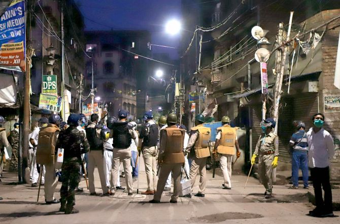 Police personnel stand guard after a mob attacked several policemen who were enforcing lockdown to prevent the spread of coronavirus at Tikiapara in Howrah district, on Tuesday. Photograph: PTI Photo