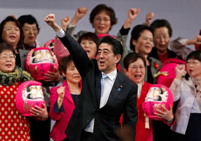 Prime Minister Abe Shinzo raises his fist with members of the ruling Liberal Democratic Party holding Daruma dolls, which are believed to bring good luck, during the annual party convention in Tokyo, March 8, 2015. Photograph: Yuya Shino/Reuters