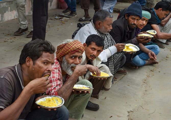 Homeless Indians and daily wagers eat food at a government shelter near the Nigam Bodh ghat in New Delhi, March 26, 2020. Photograph: Manvender Vashist/PTI Photo