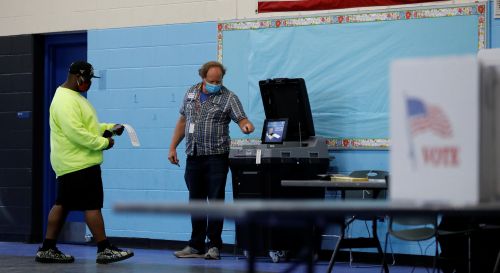 A poll worker shows a voter where to put his completed ballot at a polling station during the election in Charlotte, North Carolina