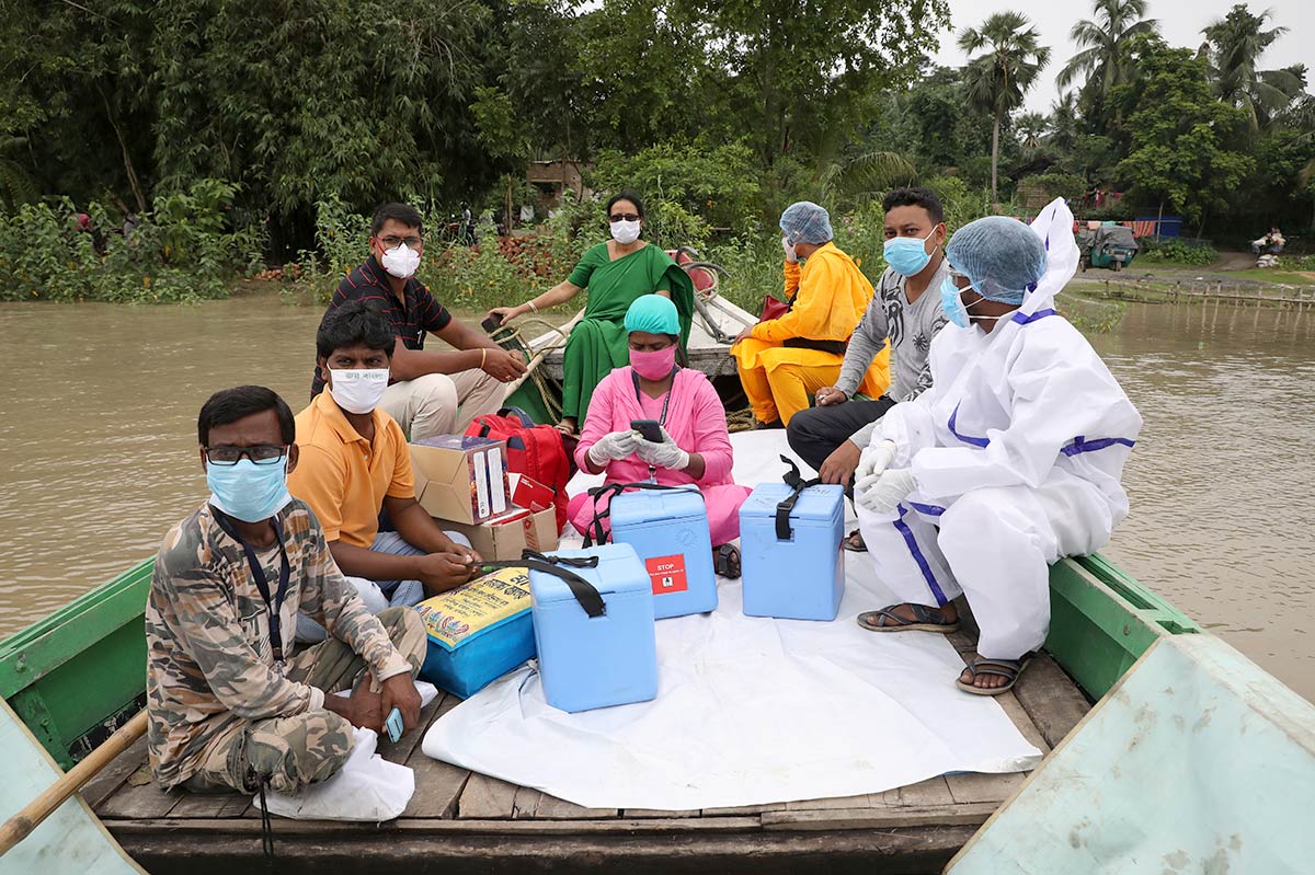 Healthcare workers cross a river to inoculate villagers