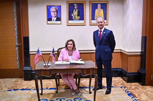 Nancy Pelosi signs the Visitors' Book in Malaysia