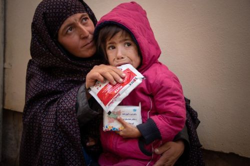 A mother with her child holding a UN food packet handout