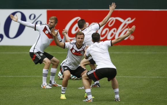Germany's national soccer players Christoph Kramer (L), Mario Goetze (2nd L) and teammates warm up during a training session 
