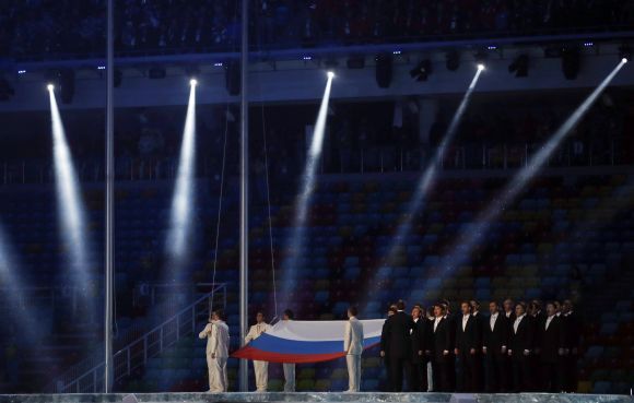 Performers raise the Russian national flag during the opening ceremony of the 2014 Sochi Winter Olympics