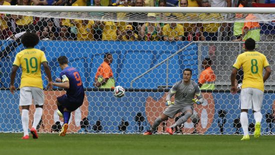 Robin van Persie of the Netherlands (2nd L) shoots to score his penalty past Brazil's Julio Cesar 