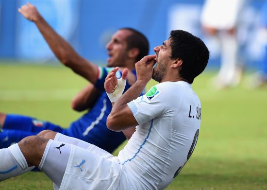 Luis Suarez of Uruguay and Giorgio Chiellini of Italy react after a clash during the 2014 FIFA World Cup