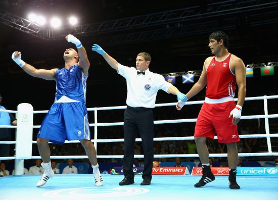 Ross Henderson of Scotland (blue) celebrates victory over Parveen Parveen Kumar of India in the Men's Super Heavy +91kg preliminaries at Scottish Exhibition And Conference Centre during day two of the Glasgow 2014 Commonwealth Games 